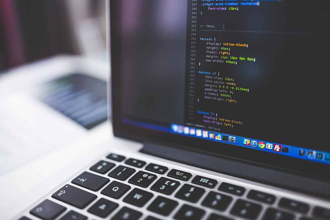 Kod programistyczny na ekranie laptopa, symbol konferencji bezpieczeństwa cyfrowego