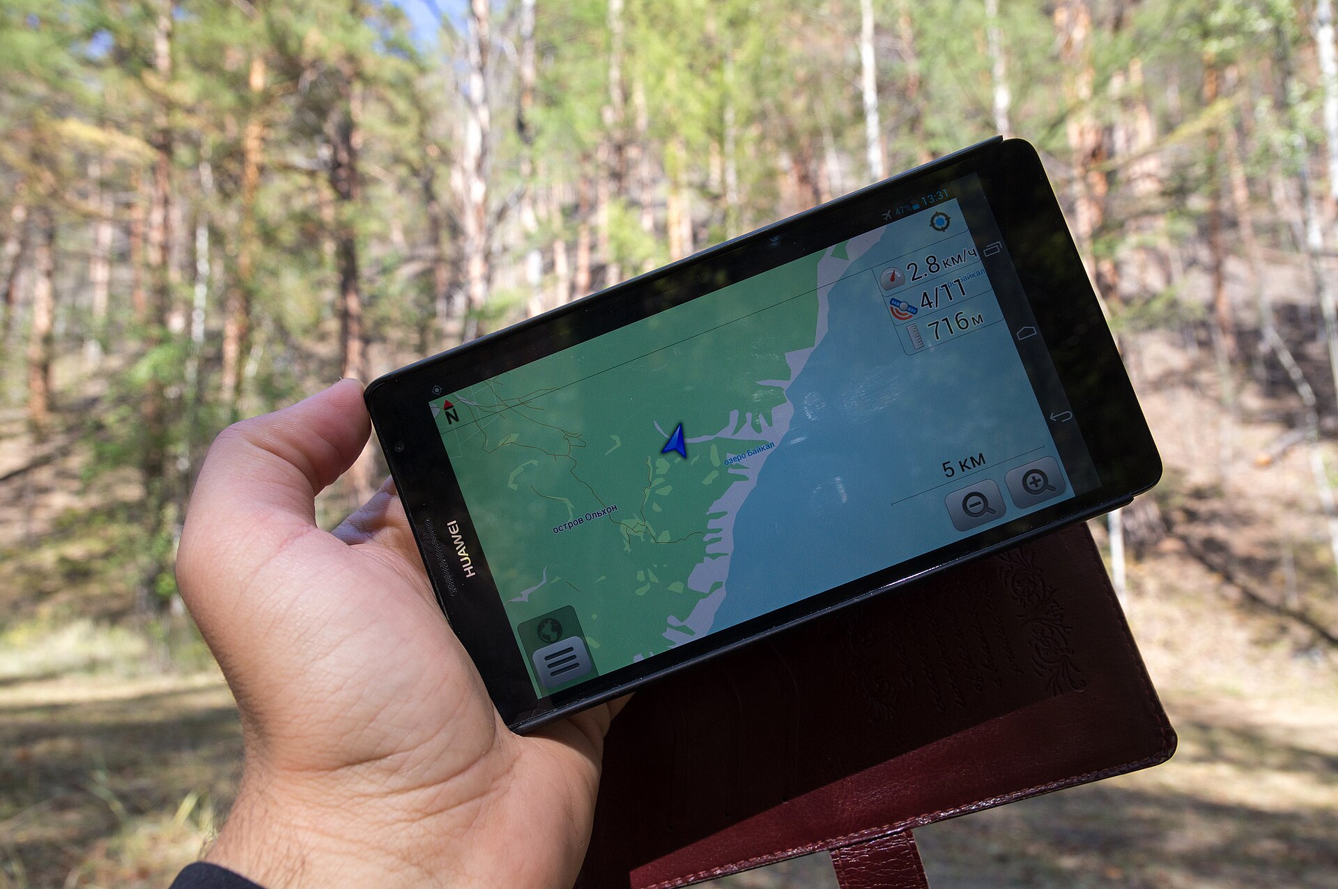 Smartfon z nawigacją GPS trzymany w ręce podczas podróży
