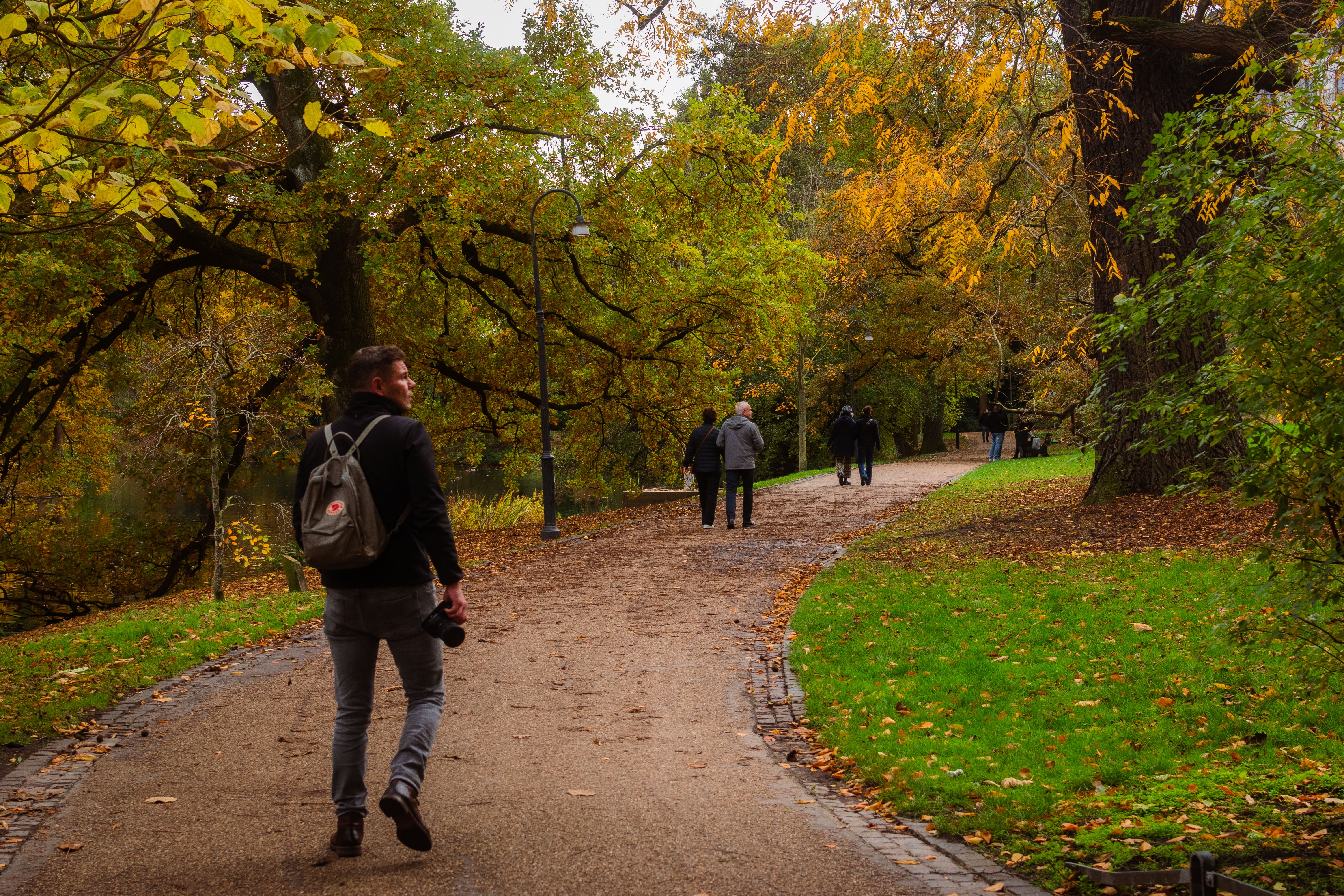 Ludzie idący przez park w jesiennych barwach
